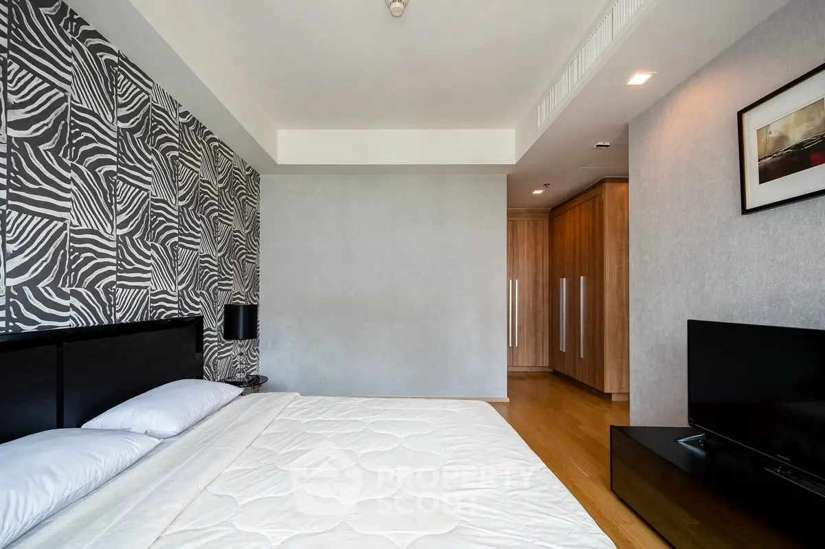 Modern bedroom with stylish zebra-patterned accent wall and sleek wooden flooring.