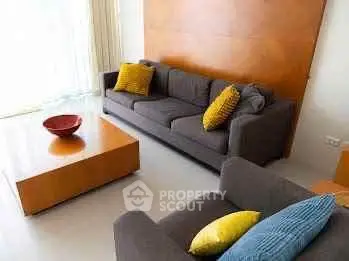 Modern living room with stylish furniture and vibrant cushions, perfect for relaxation and entertaining.