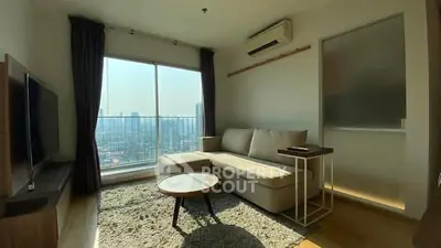 Modern living room with city view, featuring a cozy sofa and large window for natural light.