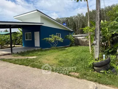 Charming blue house with modern design and lush green surroundings, perfect for serene living.