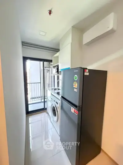 Modern kitchen with sleek appliances and balcony access in a stylish apartment.