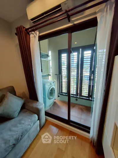 Cozy living room with balcony featuring washing machine and modern decor.