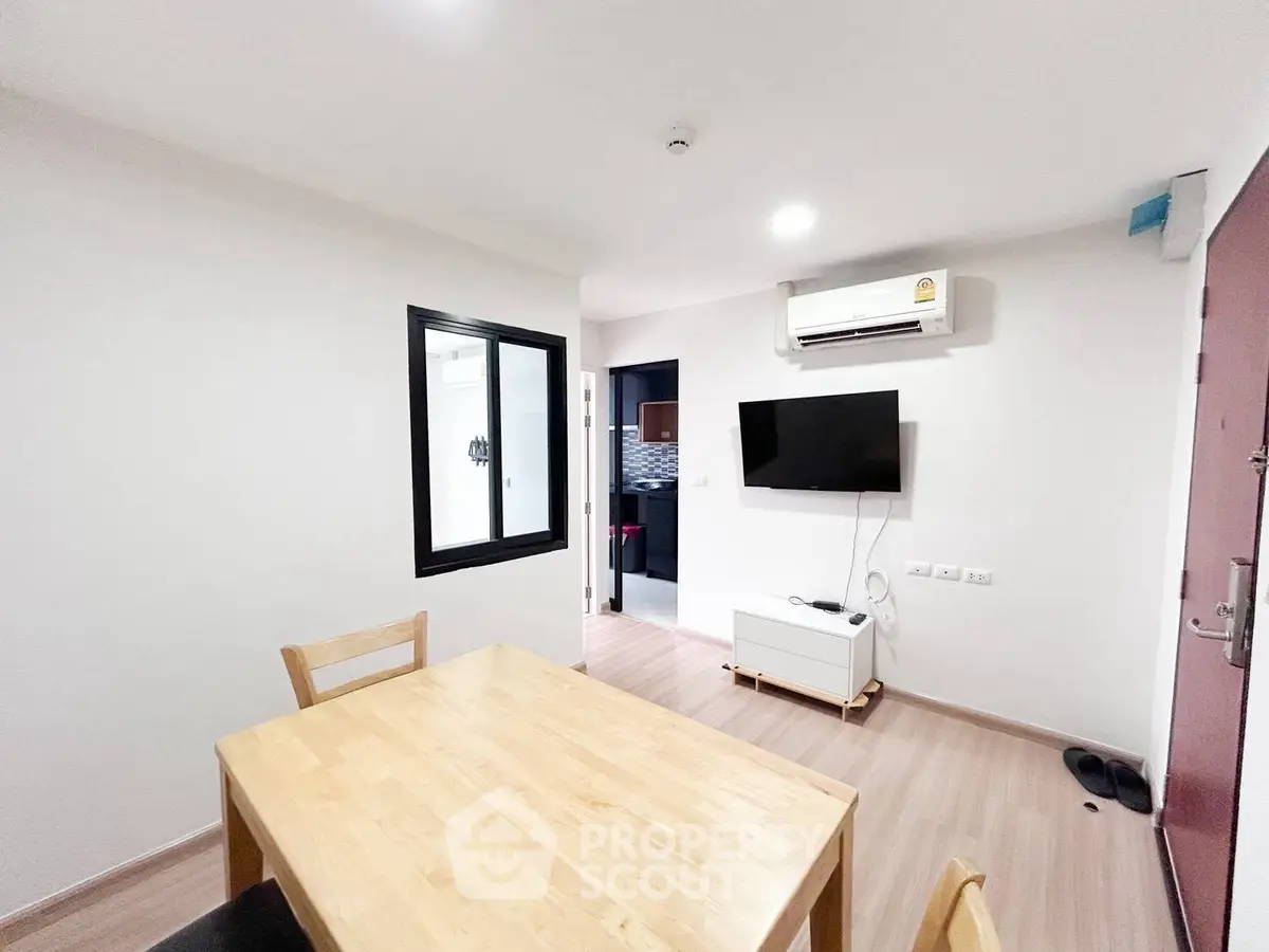 Modern dining area with wooden table and wall-mounted TV in a cozy apartment