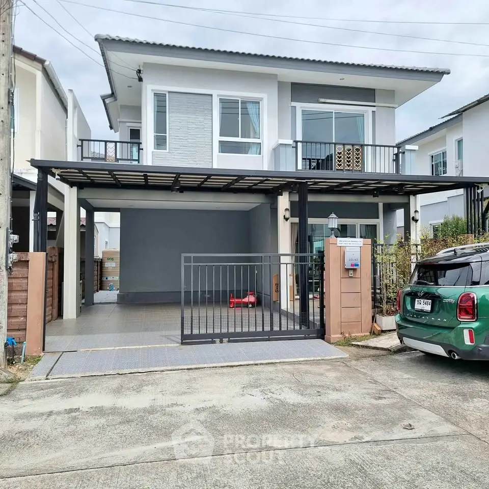 Modern two-story house with carport and balcony in suburban neighborhood.