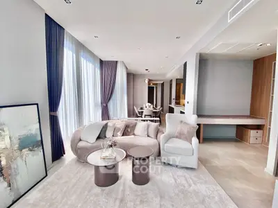 Luxurious modern living room with elegant furniture and floor-to-ceiling windows in a high-end apartment.