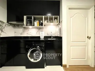 Modern kitchen with sleek black cabinetry and built-in washing machine
