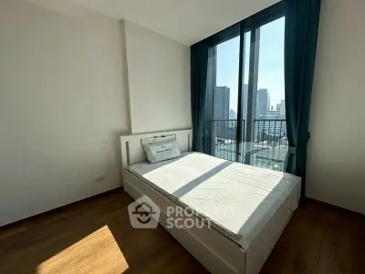 Modern bedroom with large window offering stunning city views, featuring a cozy bed and elegant wooden flooring.