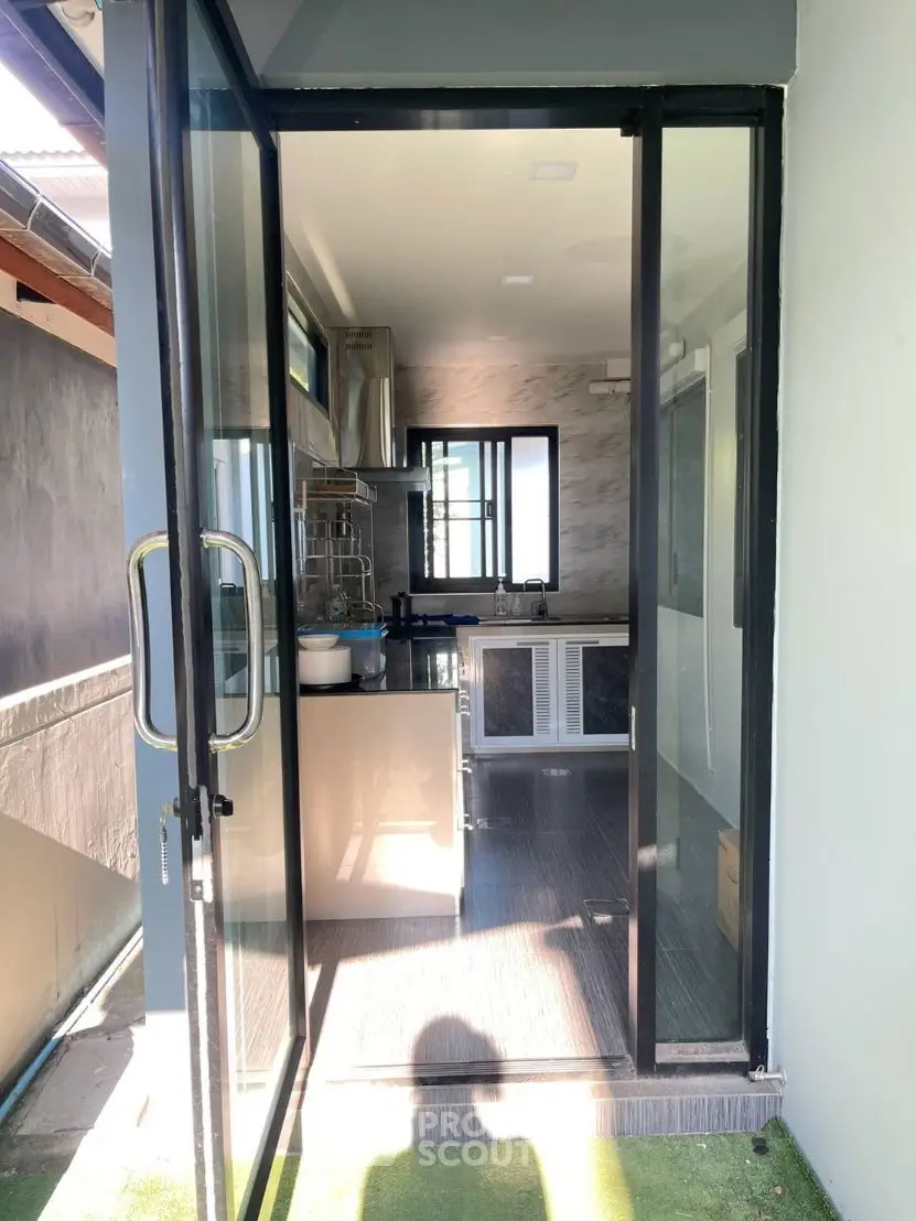 Modern kitchen with glass doors and sleek cabinetry, abundant natural light, perfect for culinary enthusiasts.