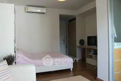 Cozy bedroom with wooden flooring, air conditioning, and modern furnishings in a stylish apartment.