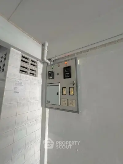 Electrical panel in a tiled utility area of a residential building.