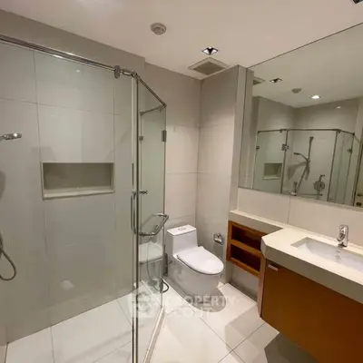 Modern bathroom with glass shower and sleek fixtures in a contemporary home.