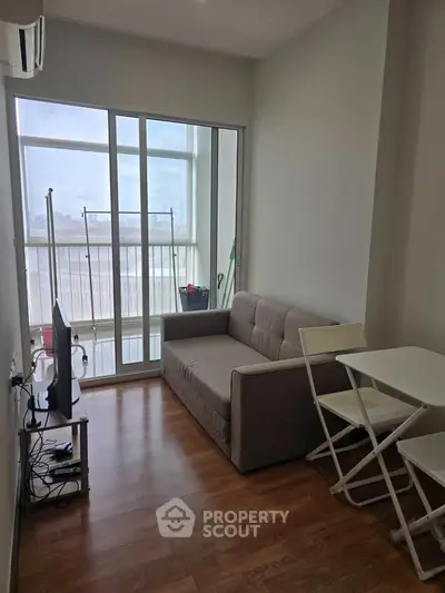 Cozy living room with modern furniture and large windows offering natural light.