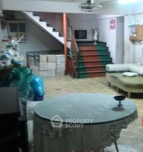 Spacious basement with staircase and eclectic decor, ideal for creative renovation.