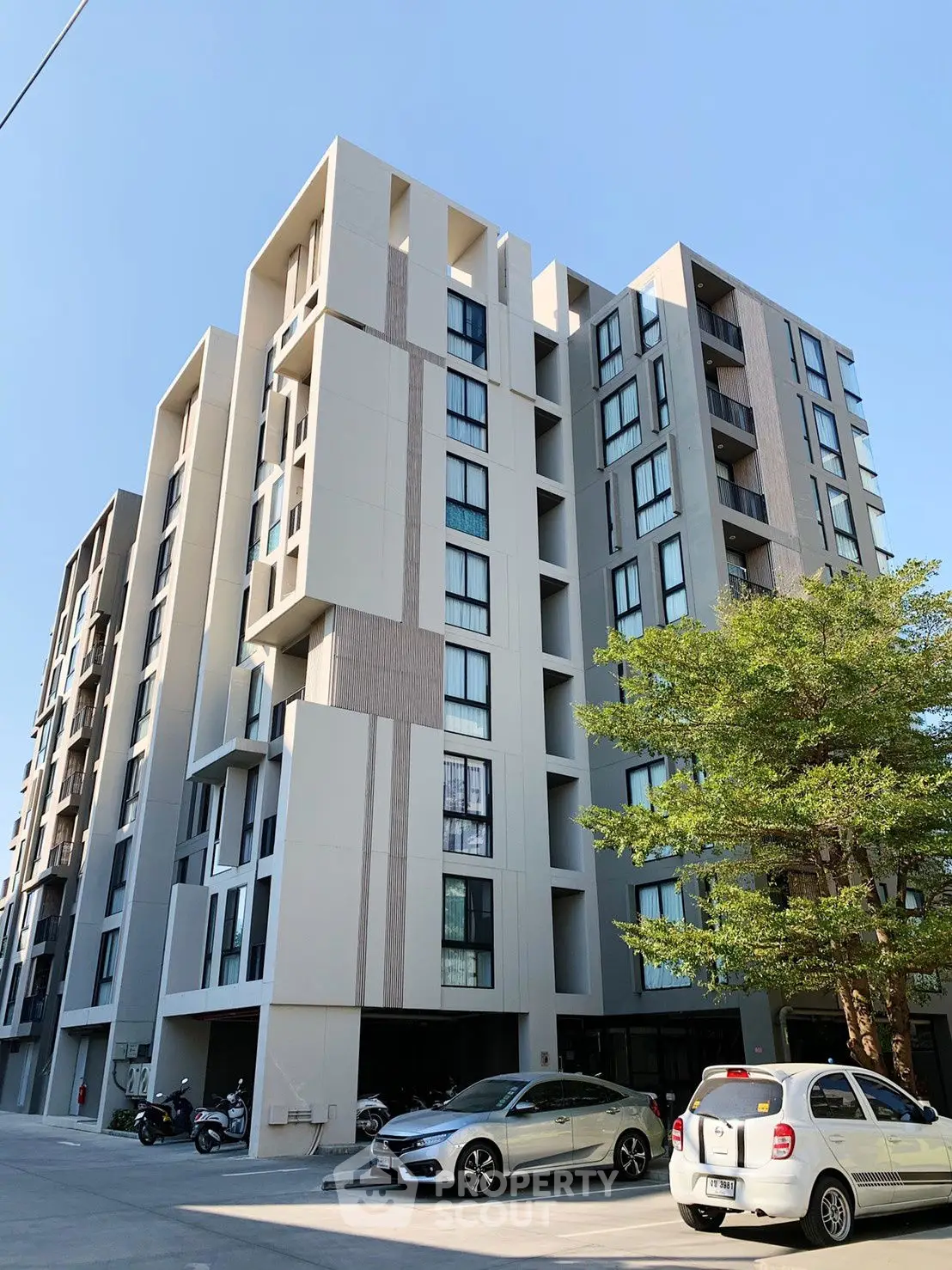 Modern apartment building with unique facade and parking area