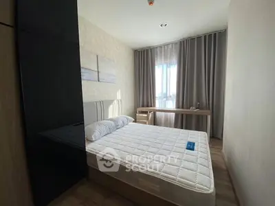 Modern bedroom with large window and stylish decor in a contemporary apartment.