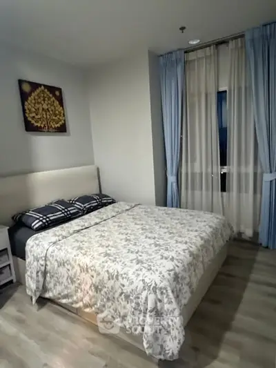 Cozy bedroom with elegant decor and large window for natural light.