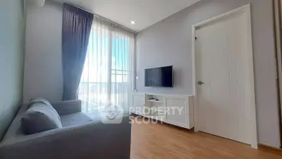 Modern living room with sleek design, featuring a cozy sofa and wall-mounted TV, perfect for relaxation.