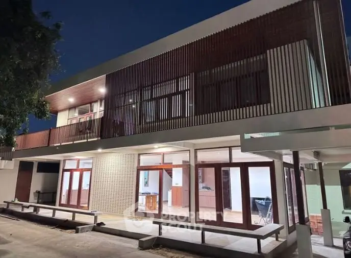 Modern architectural home exterior with sleek design and large windows at night.