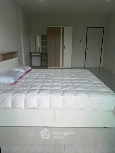 Spacious bedroom with modern furniture and ample natural light