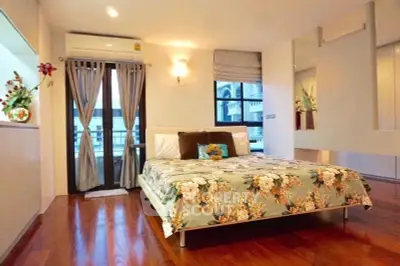 Spacious bedroom with elegant decor and balcony access in modern apartment.