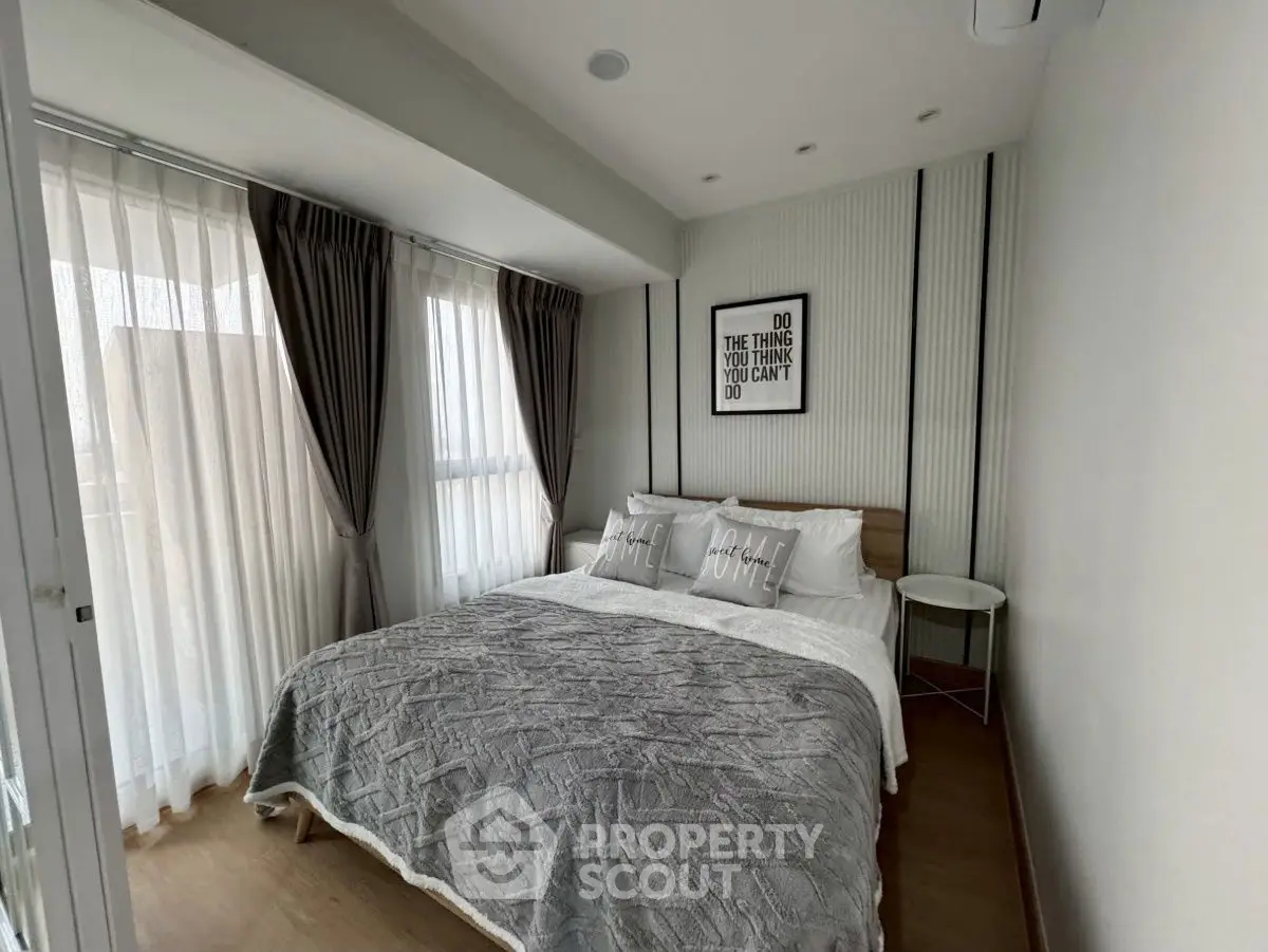 Cozy modern bedroom with stylish decor and ample natural light