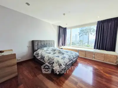 Spacious bedroom with city view and elegant wooden flooring