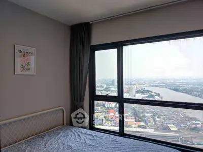 Stunning bedroom with panoramic city and river view from large window, perfect for urban living.