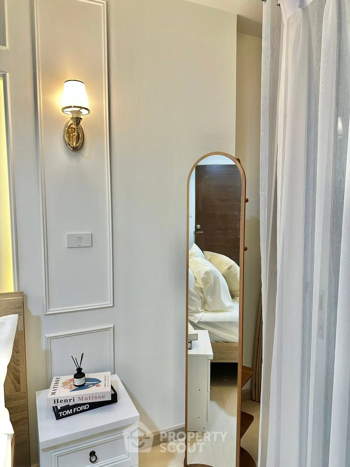 Elegant bedroom corner with stylish decor and full-length mirror