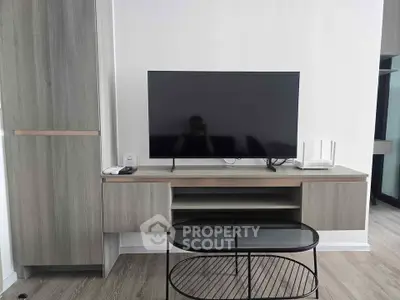 Modern living room with sleek TV stand and glass coffee table, perfect for contemporary home decor.
