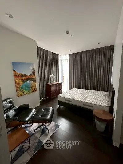 Modern bedroom with stylish furniture and large windows offering natural light.
