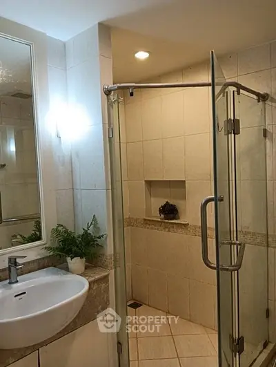 Elegant bathroom with glass shower and modern sink in a stylish home.