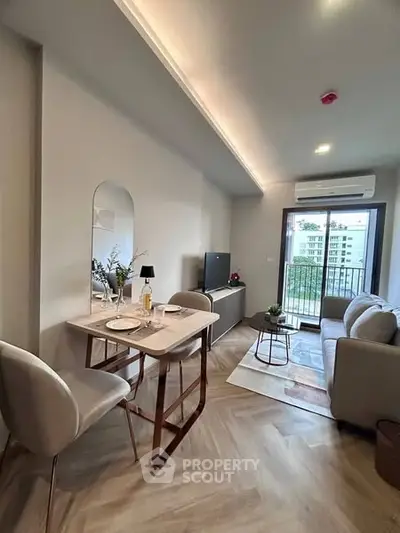 Modern living room with cozy seating and dining area, featuring a balcony view.