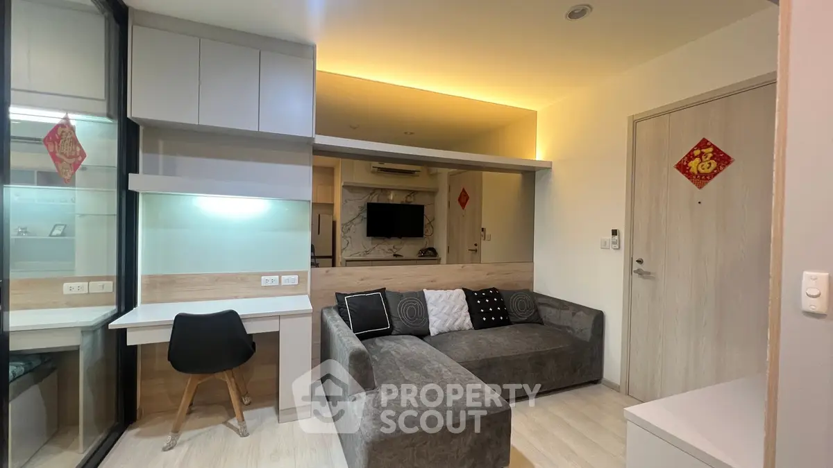 Modern living room with cozy gray sofa, built-in desk, and ambient lighting