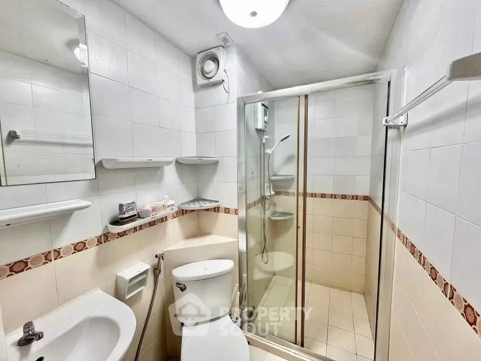 Compact bathroom with shower and modern fixtures in a real estate property.