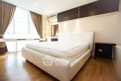 Spacious bedroom with elegant design and natural light in modern apartment.