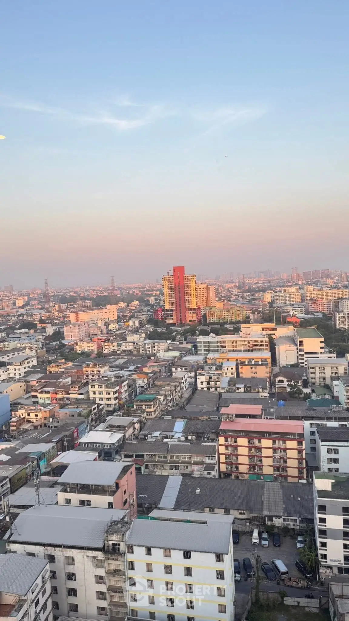 Stunning cityscape view from high-rise building showcasing vibrant urban skyline at sunset.