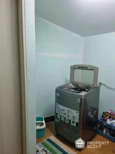 Compact laundry room with modern washing machine and storage baskets