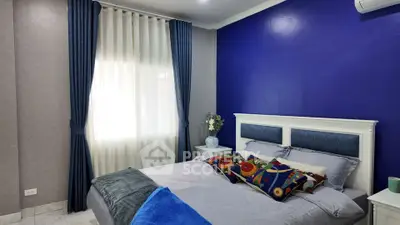 Cozy bedroom with vibrant blue accent wall and elegant curtains