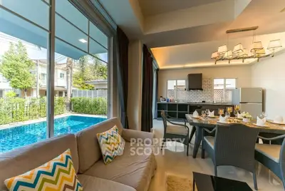Luxurious living room with pool view and modern kitchen in open layout