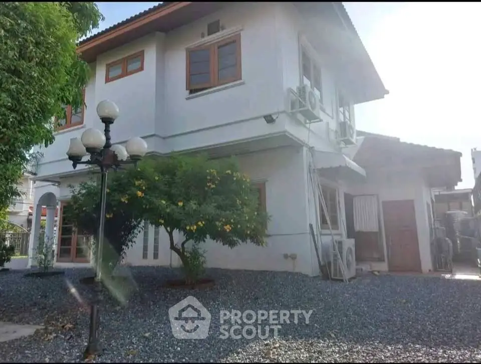 Charming two-story house with lush garden and modern exterior design.