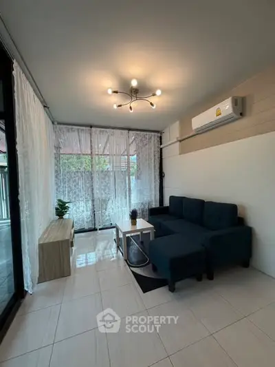 Modern living room with stylish furniture and large windows for natural light.