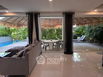 Luxurious living room with poolside view and tropical garden ambiance