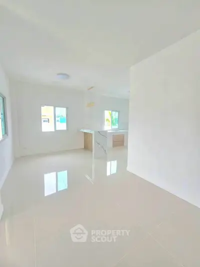 Spacious open-plan living area with modern kitchen and large windows for natural light.