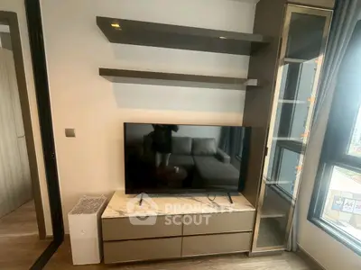 Modern living room with sleek TV stand and wall shelves, featuring a cozy sofa and large window view.
