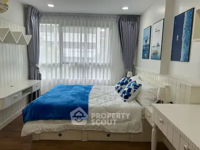 Charming bedroom with modern decor, featuring a cozy bed, stylish artwork, and ample natural light through large windows.