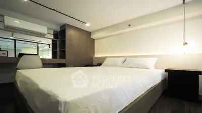 Modern bedroom with stylish decor and ambient lighting, featuring a comfortable bed and workspace.