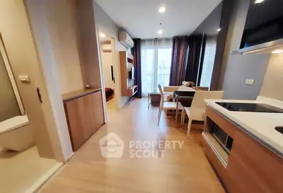 Modern open-plan living and dining area with city view, featuring sleek kitchen and cozy furnishings.