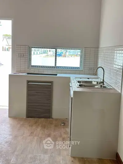 Modern kitchen with sleek design and ample natural light, featuring a compact layout and stylish finishes.