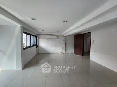 Spacious unfurnished room with large windows and air conditioning, ideal for customization.