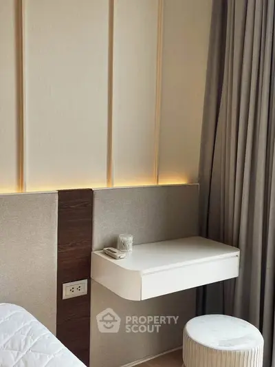 Modern bedroom corner with elegant wall paneling and cozy seating area.